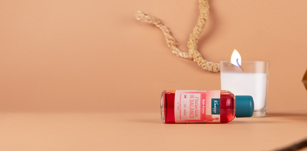 Koupelov&aacute; esence lež&iacute; na oranžov&eacute;m pozad&iacute;, &scaron;t&iacute;tek je zaostřen&yacute;